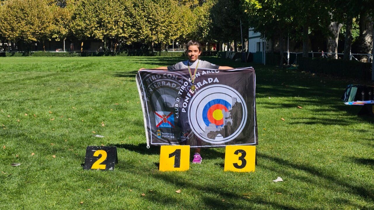 Niño sosteniendo una bandera del Club de Tiro con Arco de Ponferrada