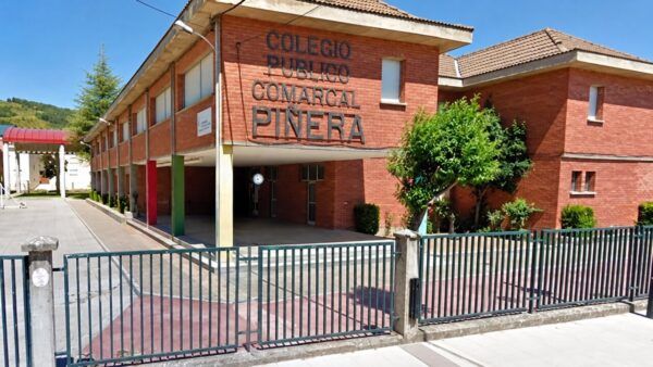 Fachada del CEIP Piñera de Vega de Espinareda con árboles y reja