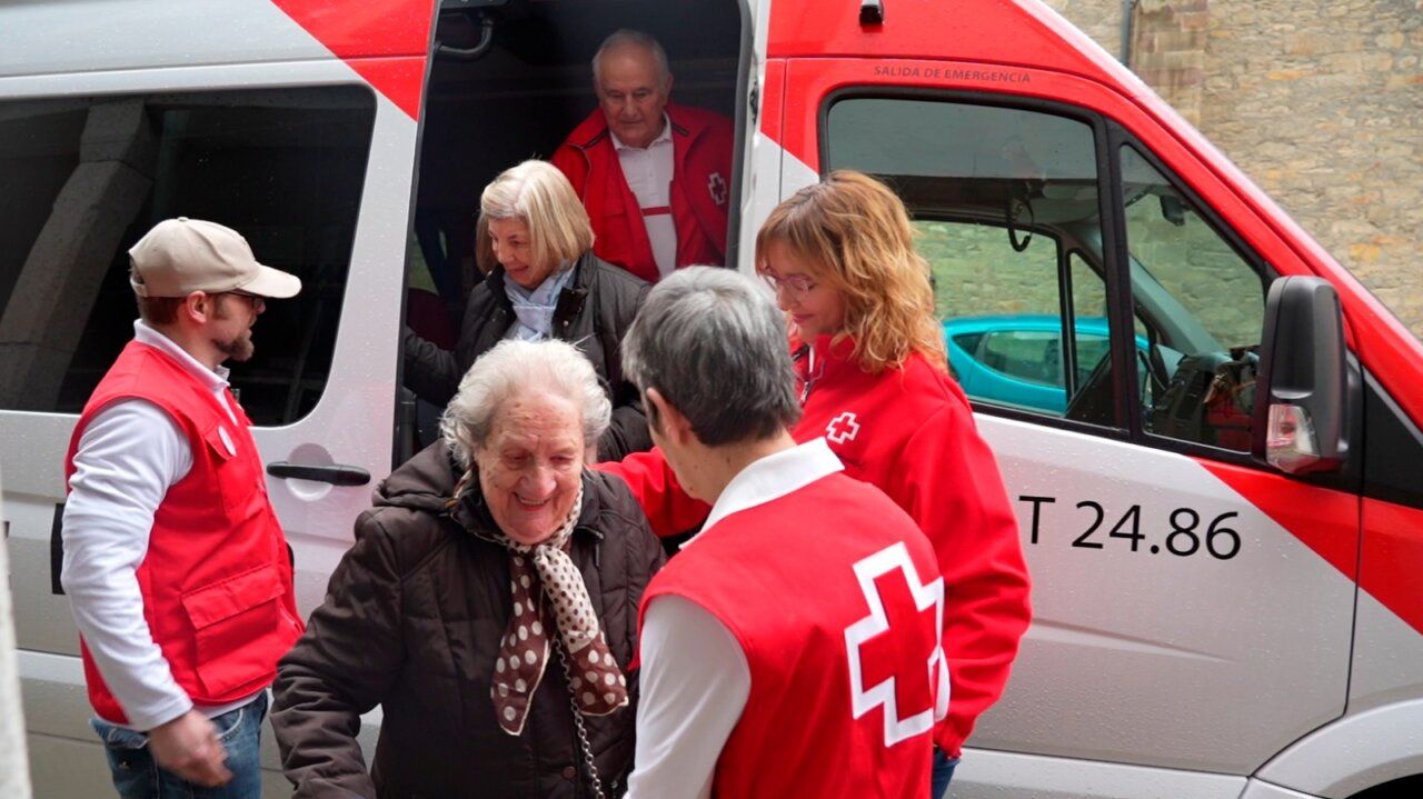 Grupo de personas mayores siendo asistidos por voluntarios de Cruz Roja