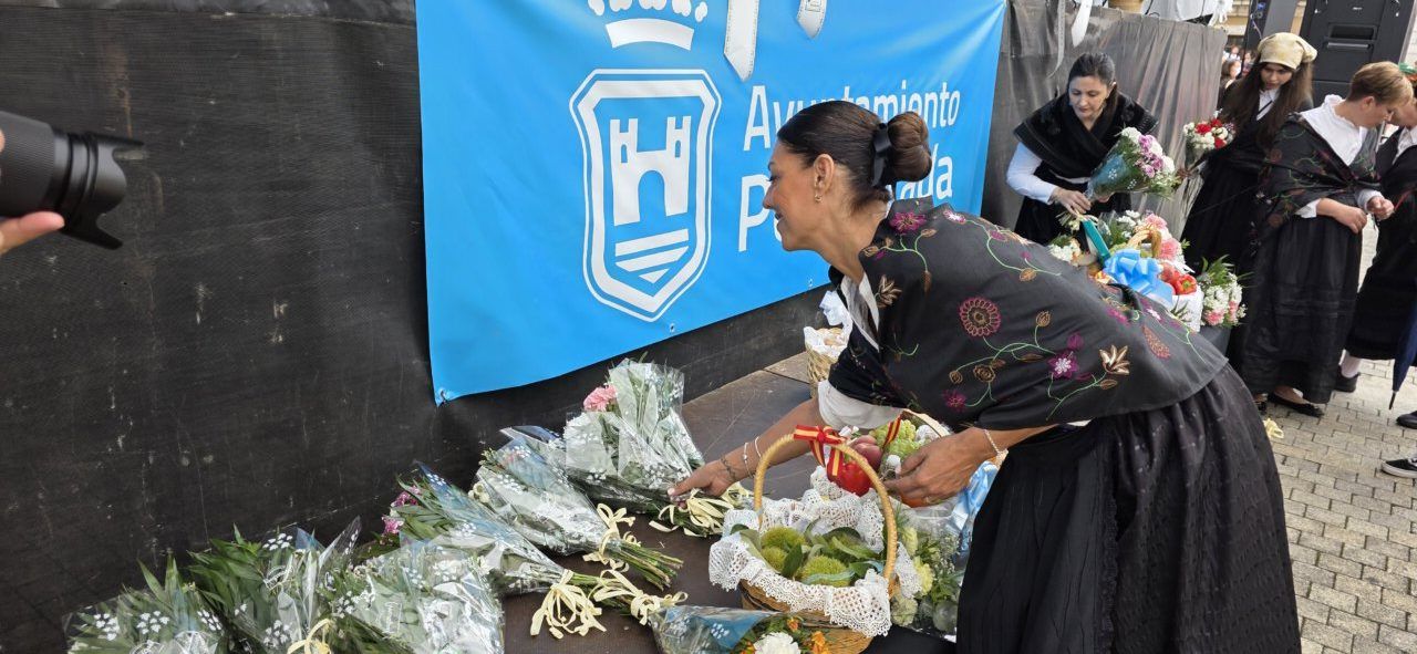 Mujer colocando ofrendas en la fiesta de La Encina en Ponferrada