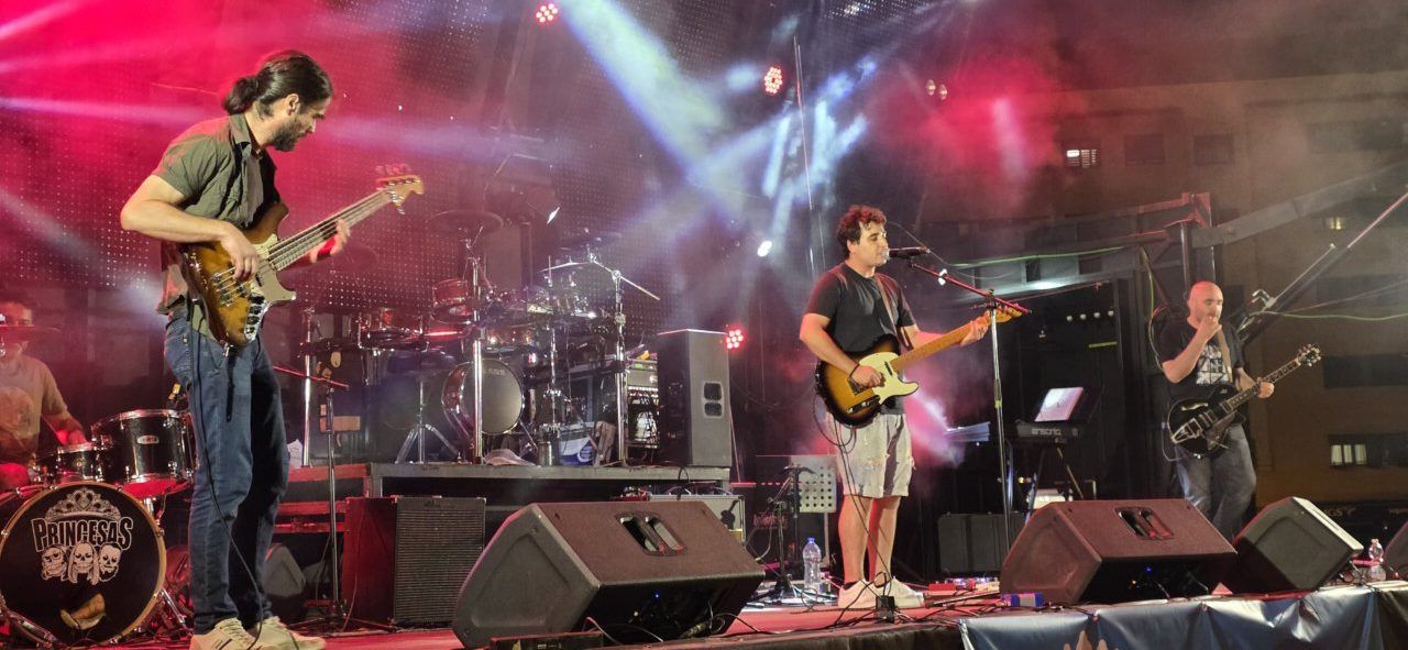 Banda tocando en un concierto con luces de colores