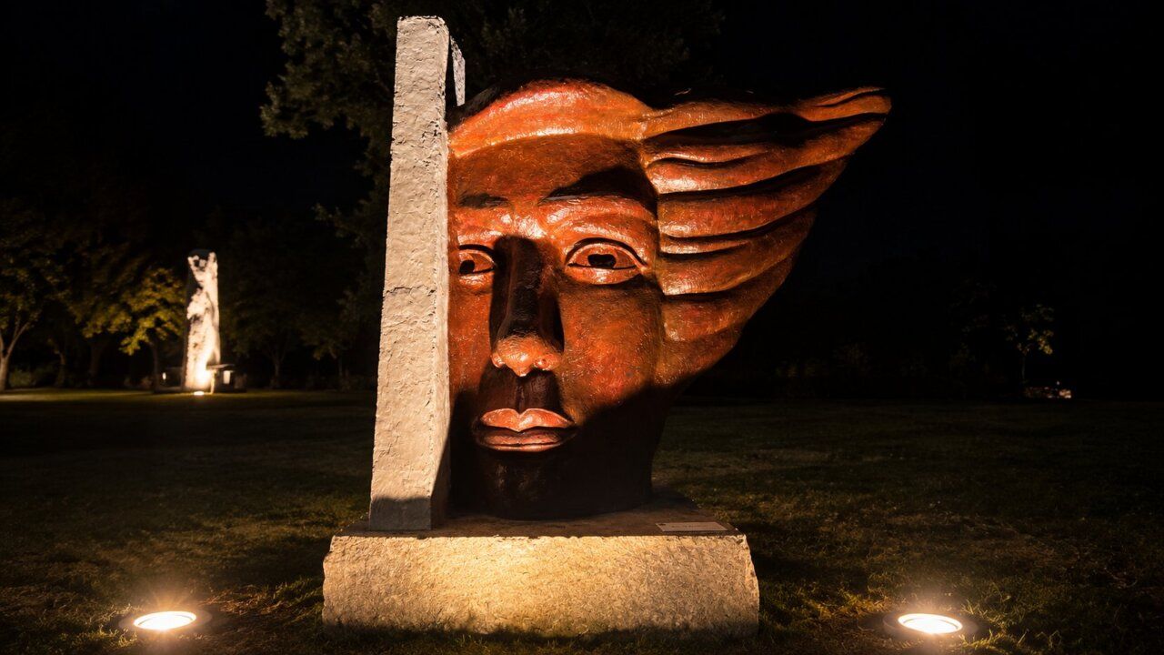 Escultura monumental iluminada en Carracedelo durante la noche