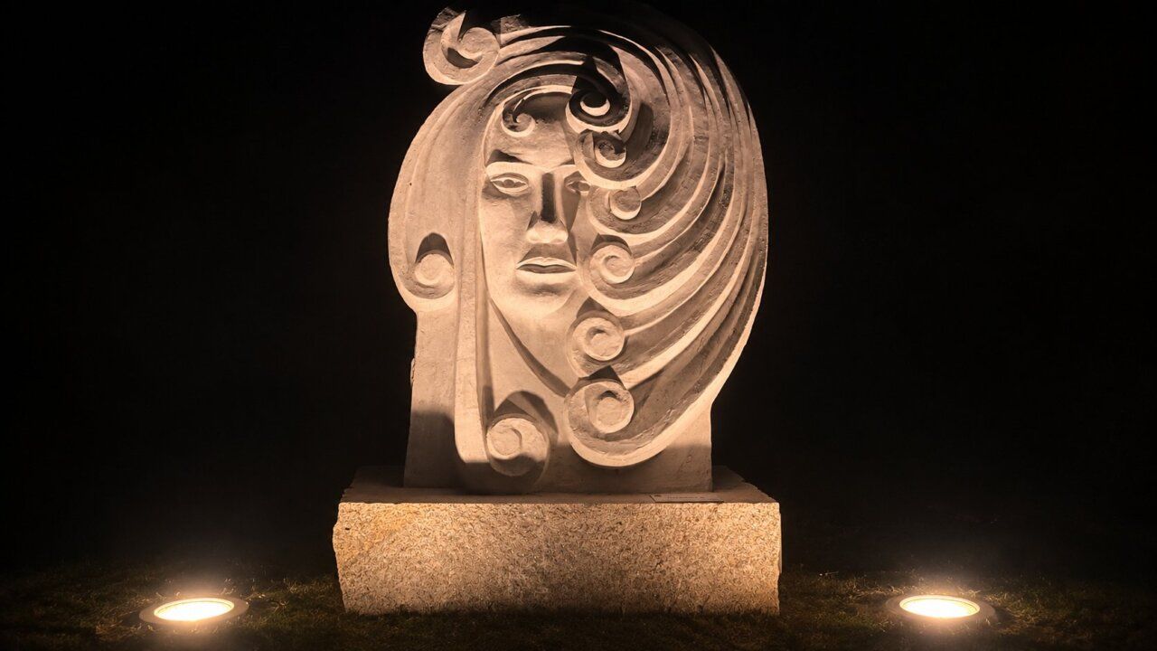 Escultura monumental iluminada en Carracedelo durante la noche