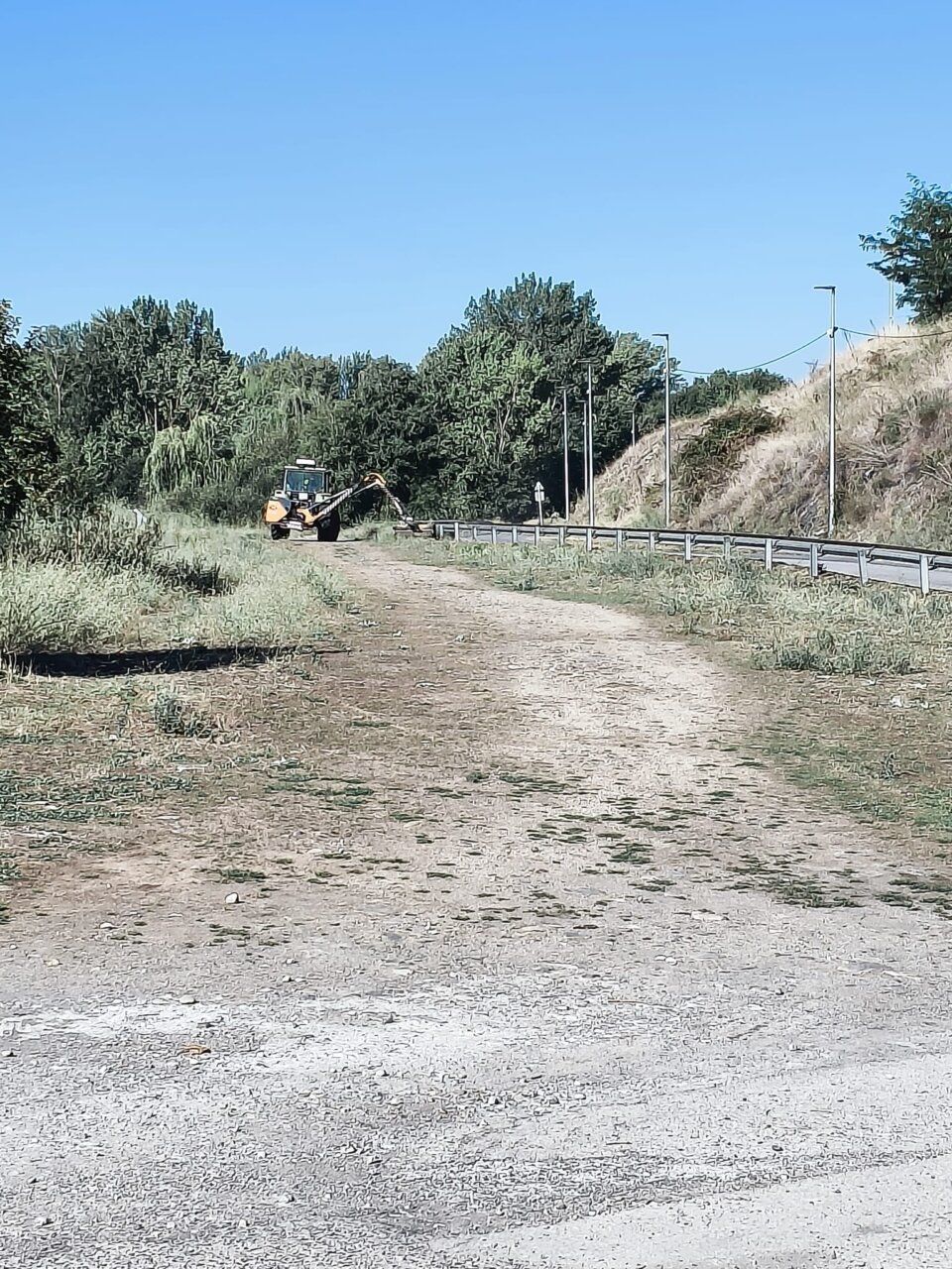 Maquinaria trabajando en un camino durante alerta de incendios en Ponferrada