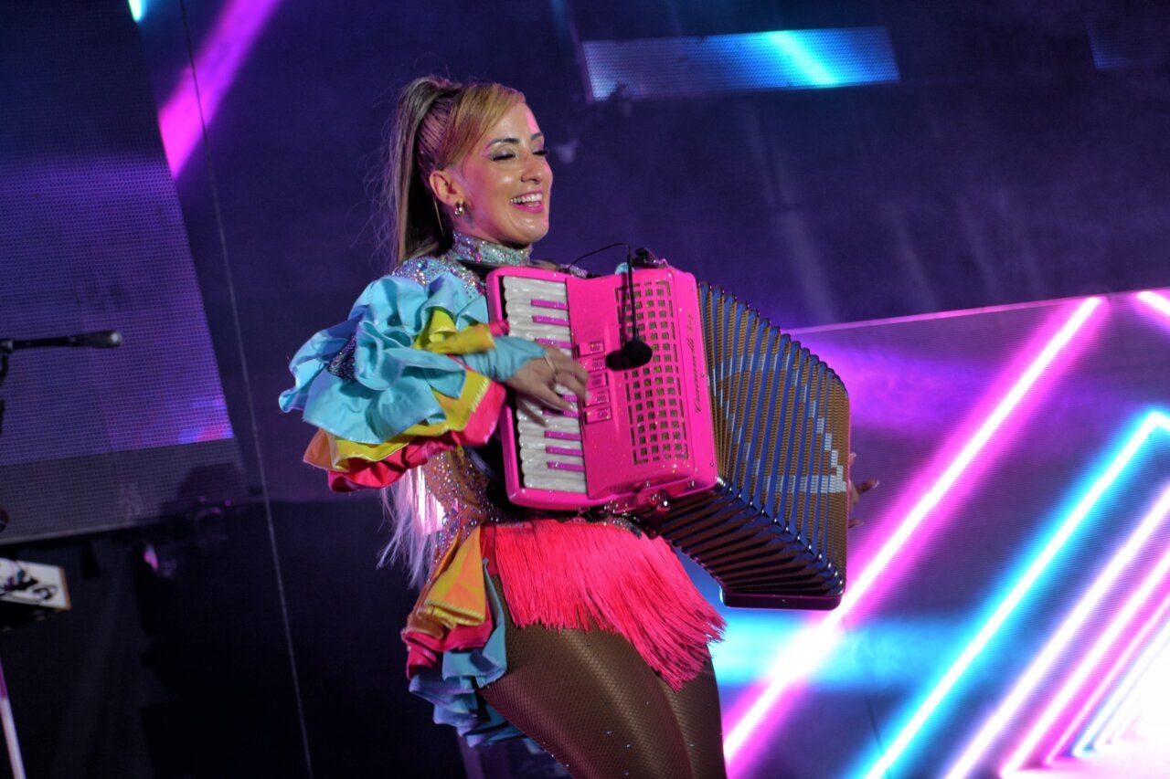 Mujer tocando acordeón en un espectáculo musical colorido