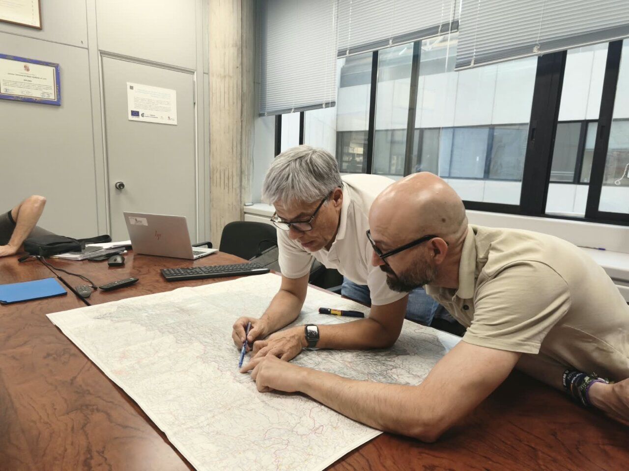 Dos personas revisando un mapa en una mesa durante un incendio forestal