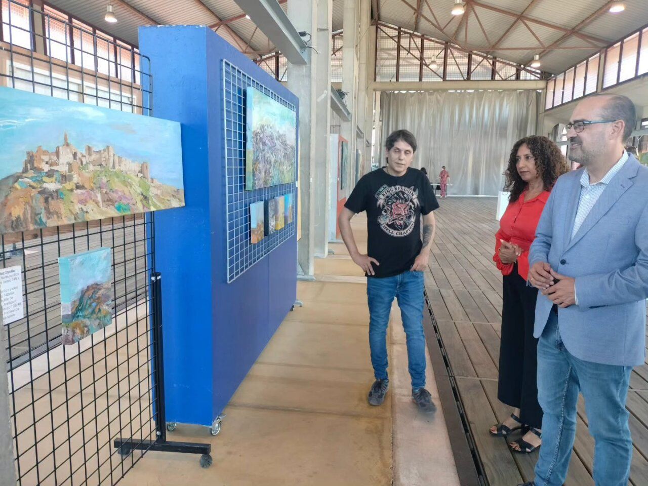 Personas observando obras de arte en el Museo del Ferrocarril de Ponferrada