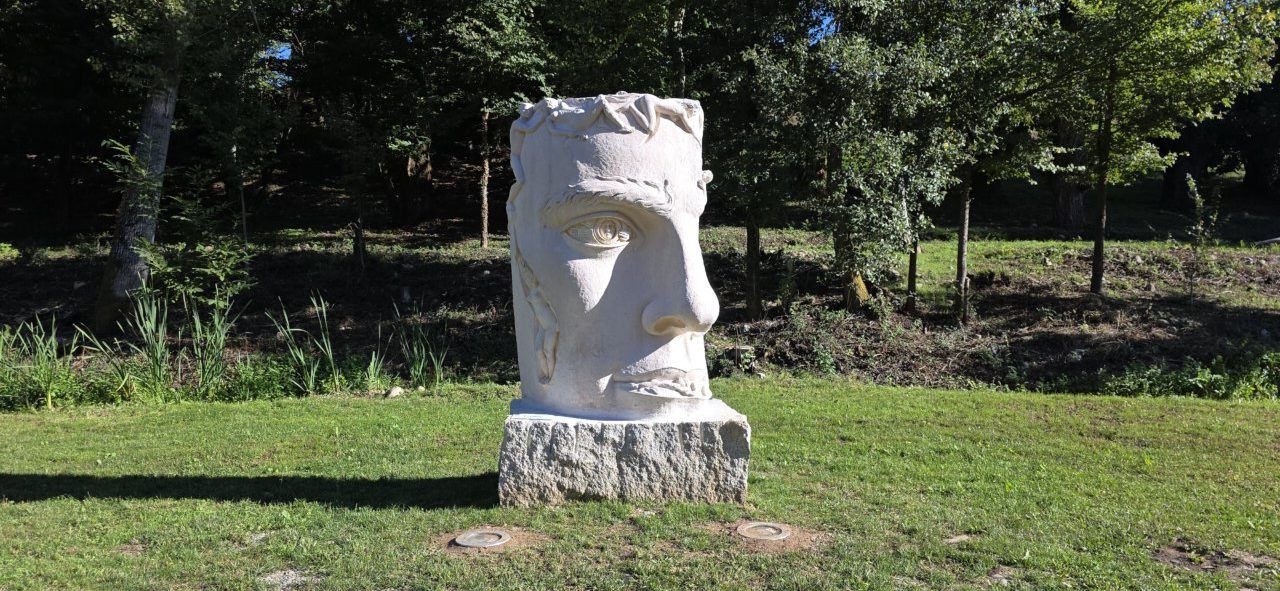 Escultura monumental de Arturo Nogueira en Carracedelo rodeada de naturaleza.