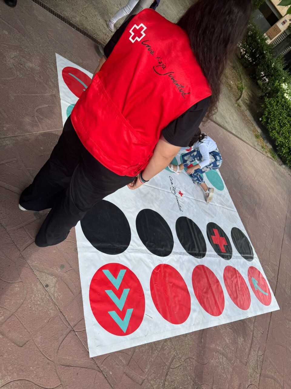 Joven con chaleco de Cruz Roja en actividad de voluntariado