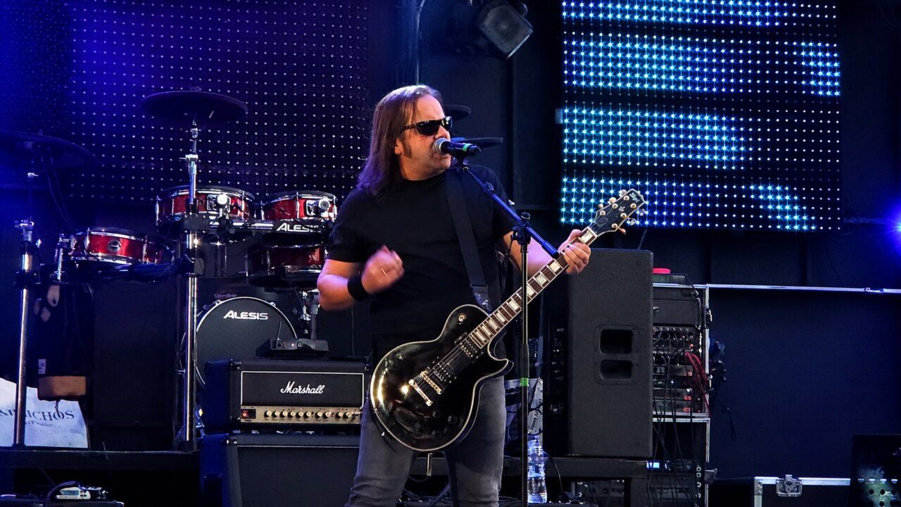 Músico tocando guitarra eléctrica en un escenario durante un concierto en Ponferrada