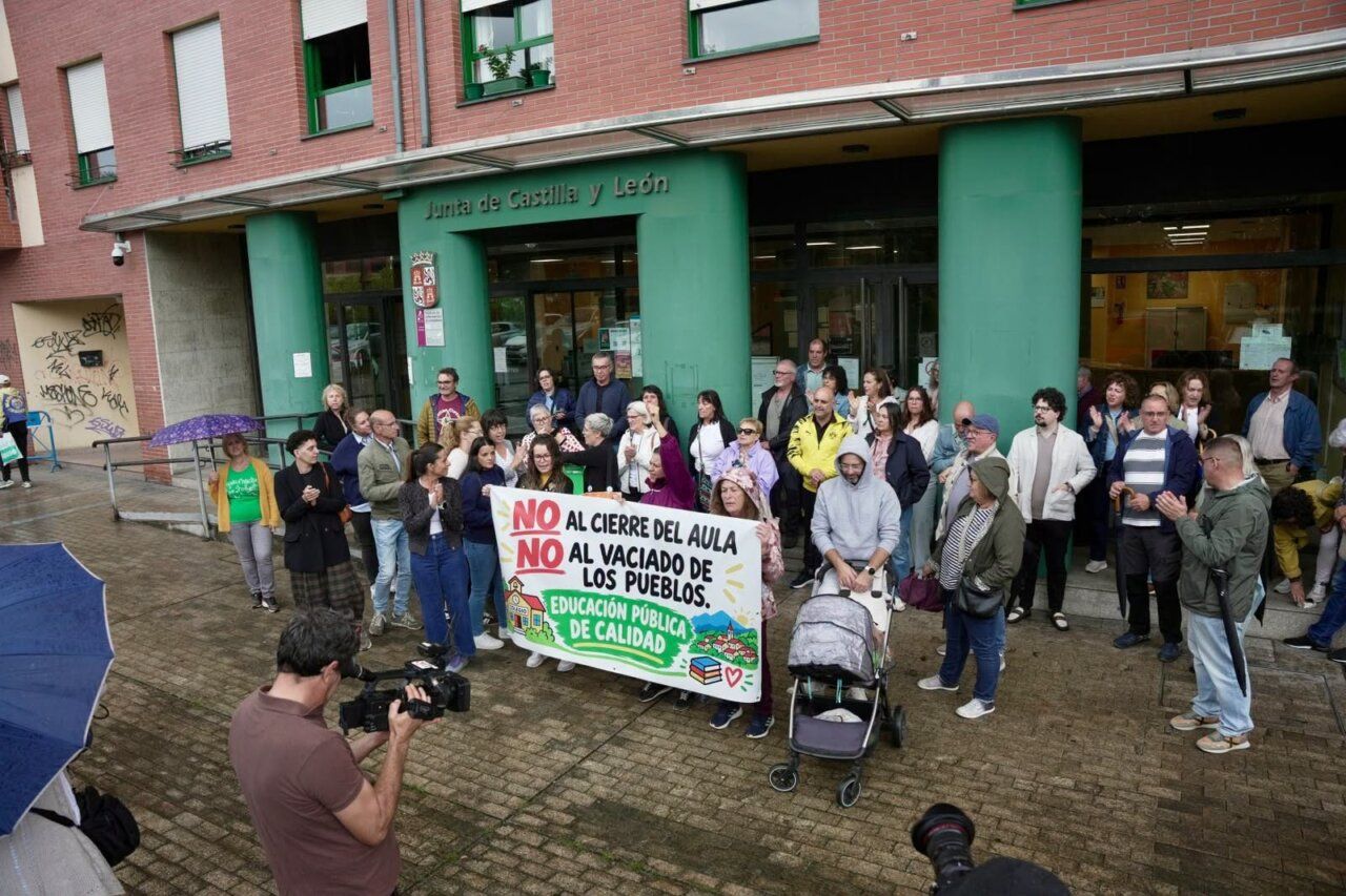 Manifestantes frente a la Junta de Castilla y León con pancarta contra el cierre de aulas