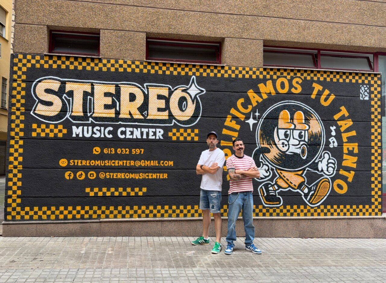Mural del Stereo Music Center con dos hombres posando frente a él