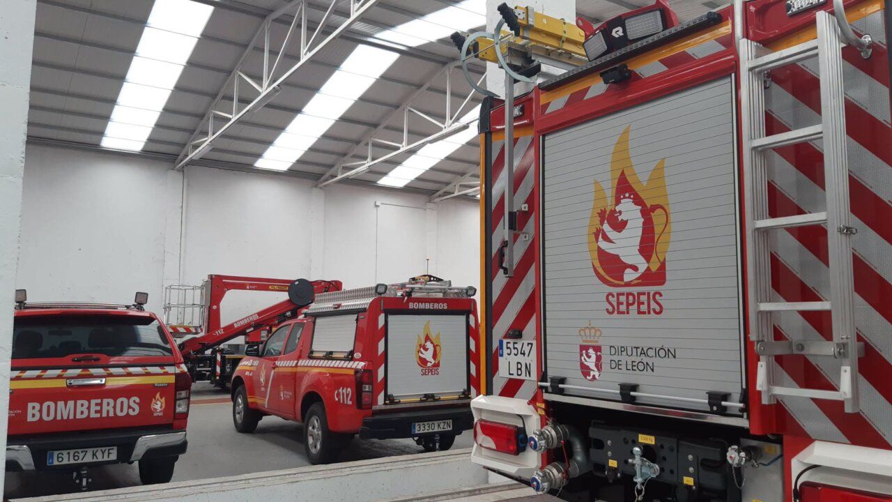 Vehículos de bomberos en un garaje con equipo de emergencia.