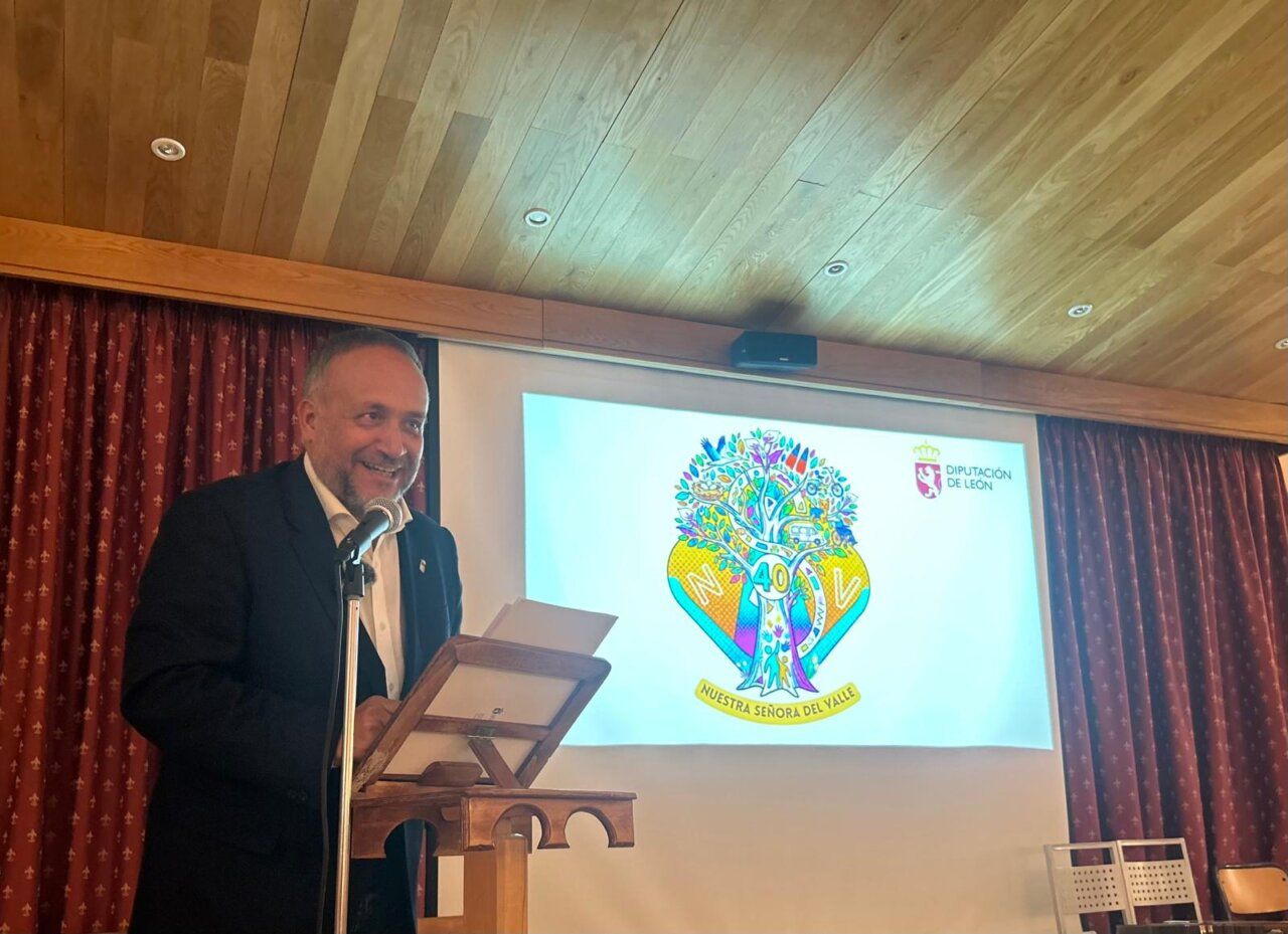 Un hombre habla desde un atril junto a una pantalla con el emblema del 40 aniversario.