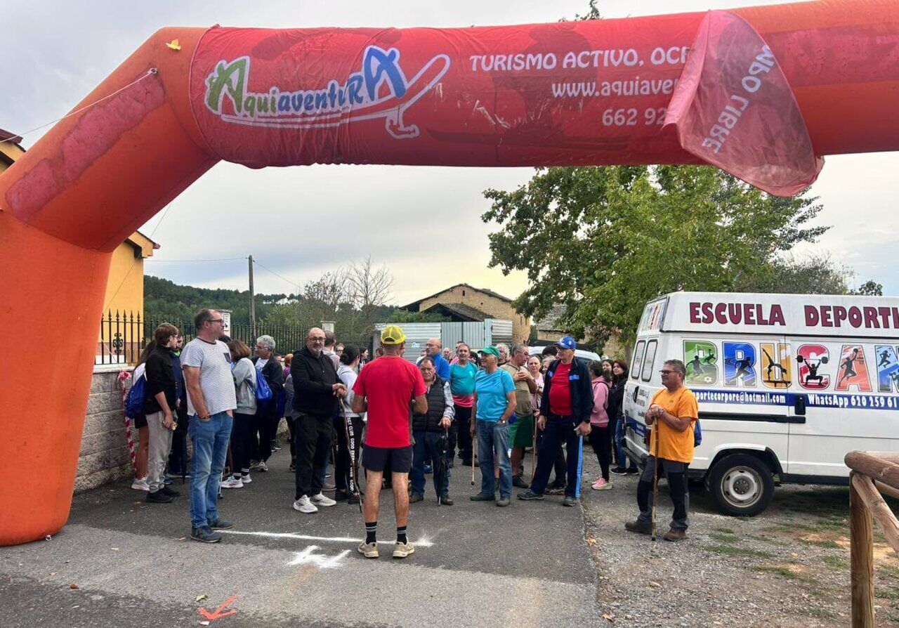 Participantes en el evento Arganza Camina bajo un arco inflable.