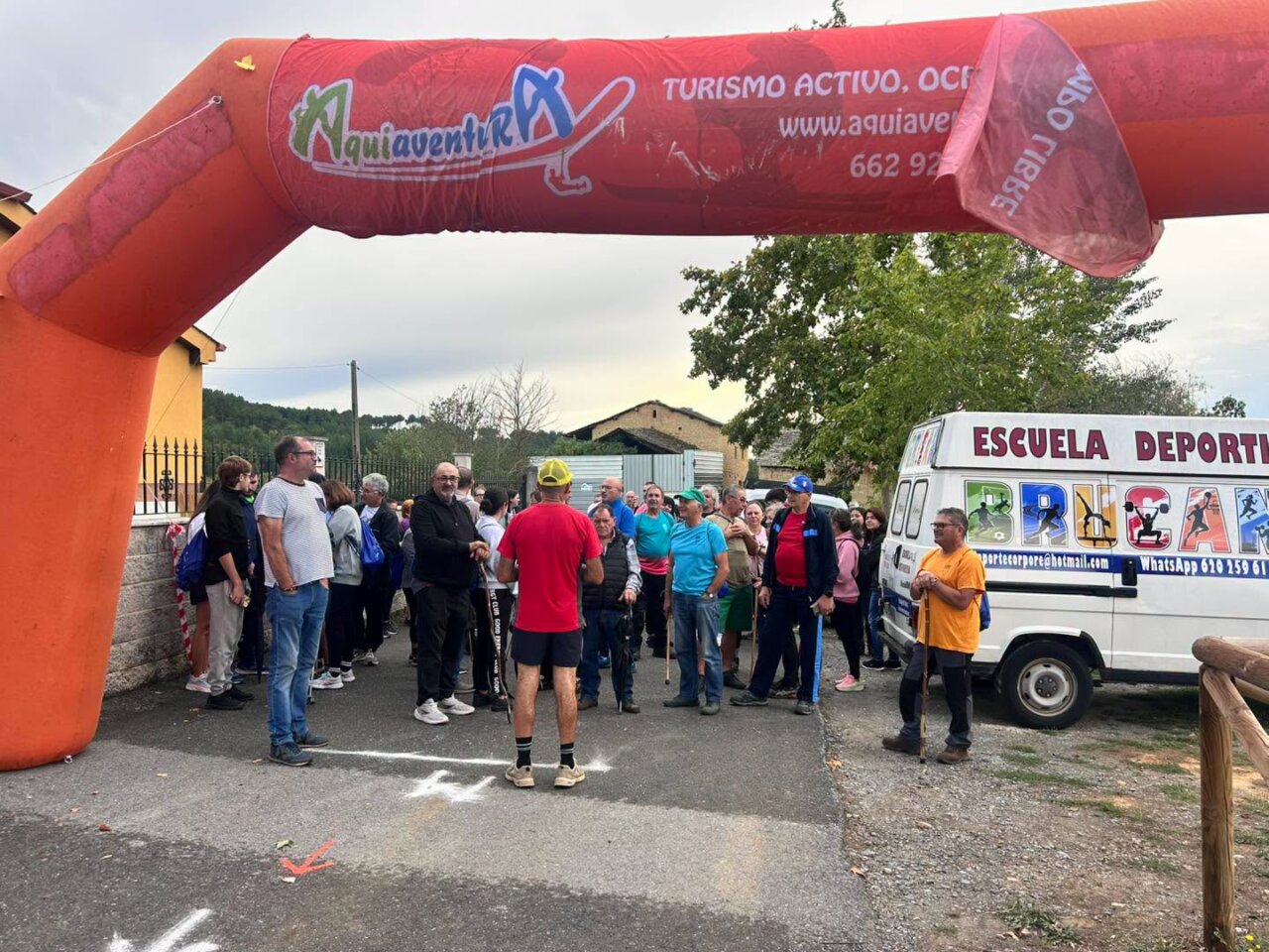 Participantes en el evento Arganza Camina bajo un arco inflable.