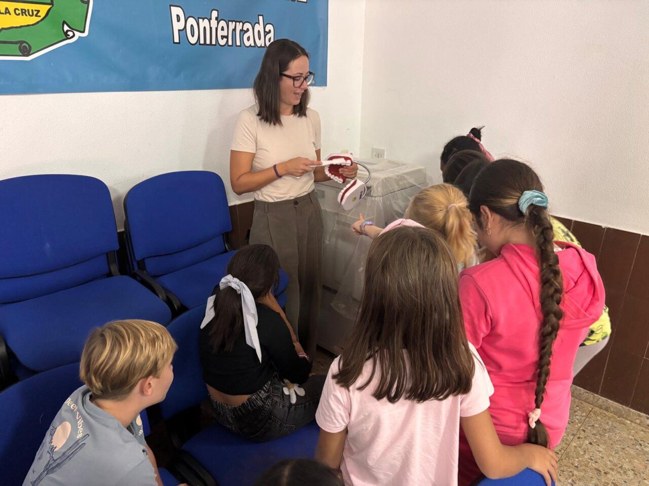 Higienista dental explica a niños sobre salud bucodental en Ponferrada
