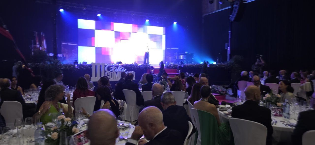 Asistentes en la III Gala del Comercio de Ponferrada con escenario iluminado