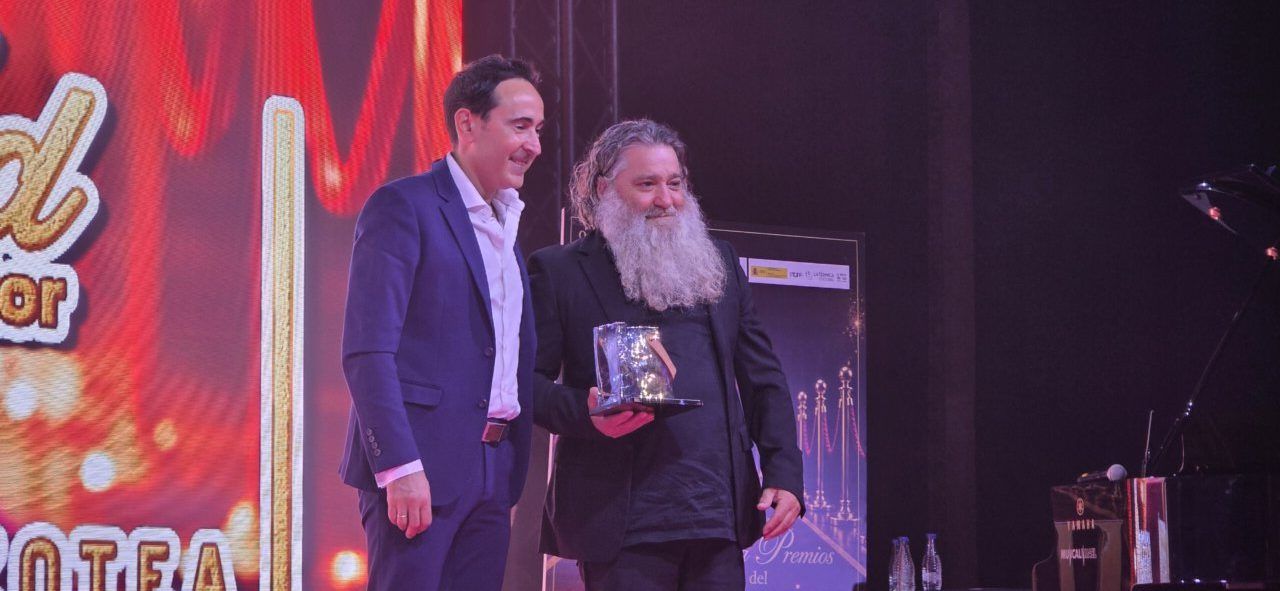 Dos hombres en una gala sosteniendo un premio en Ponferrada