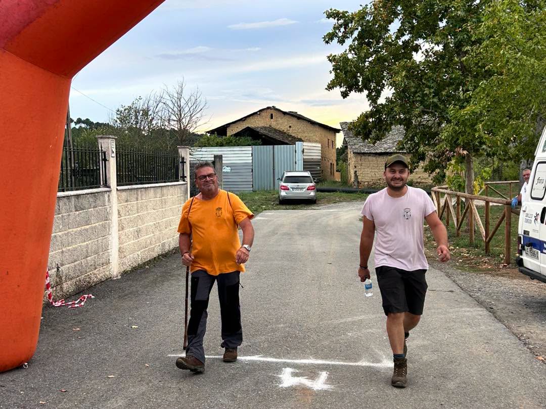 Participantes caminando en el evento Arganza Camina con un arco de meta.