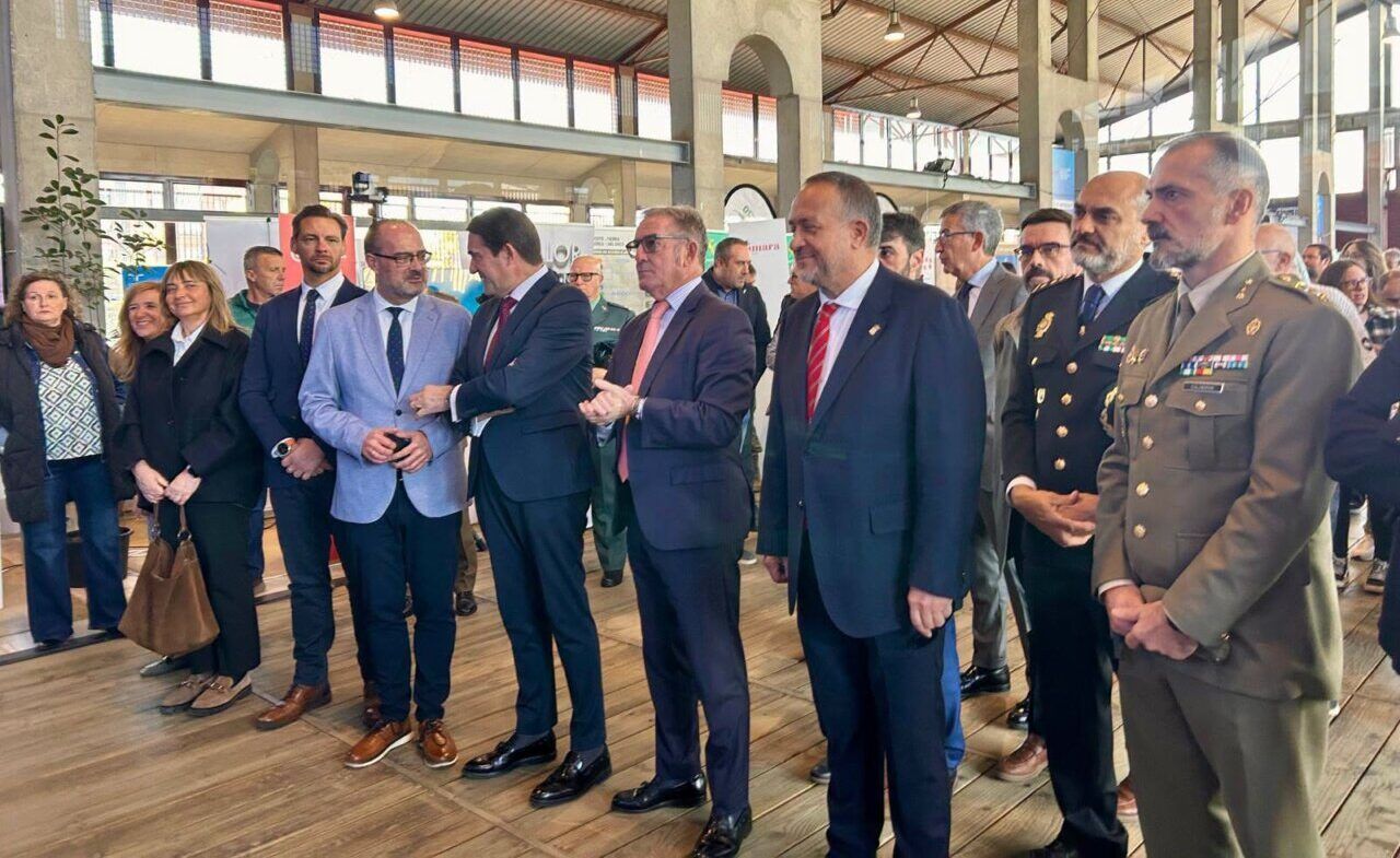 Varias personas reunidas en un pabellón con expositores al fondo