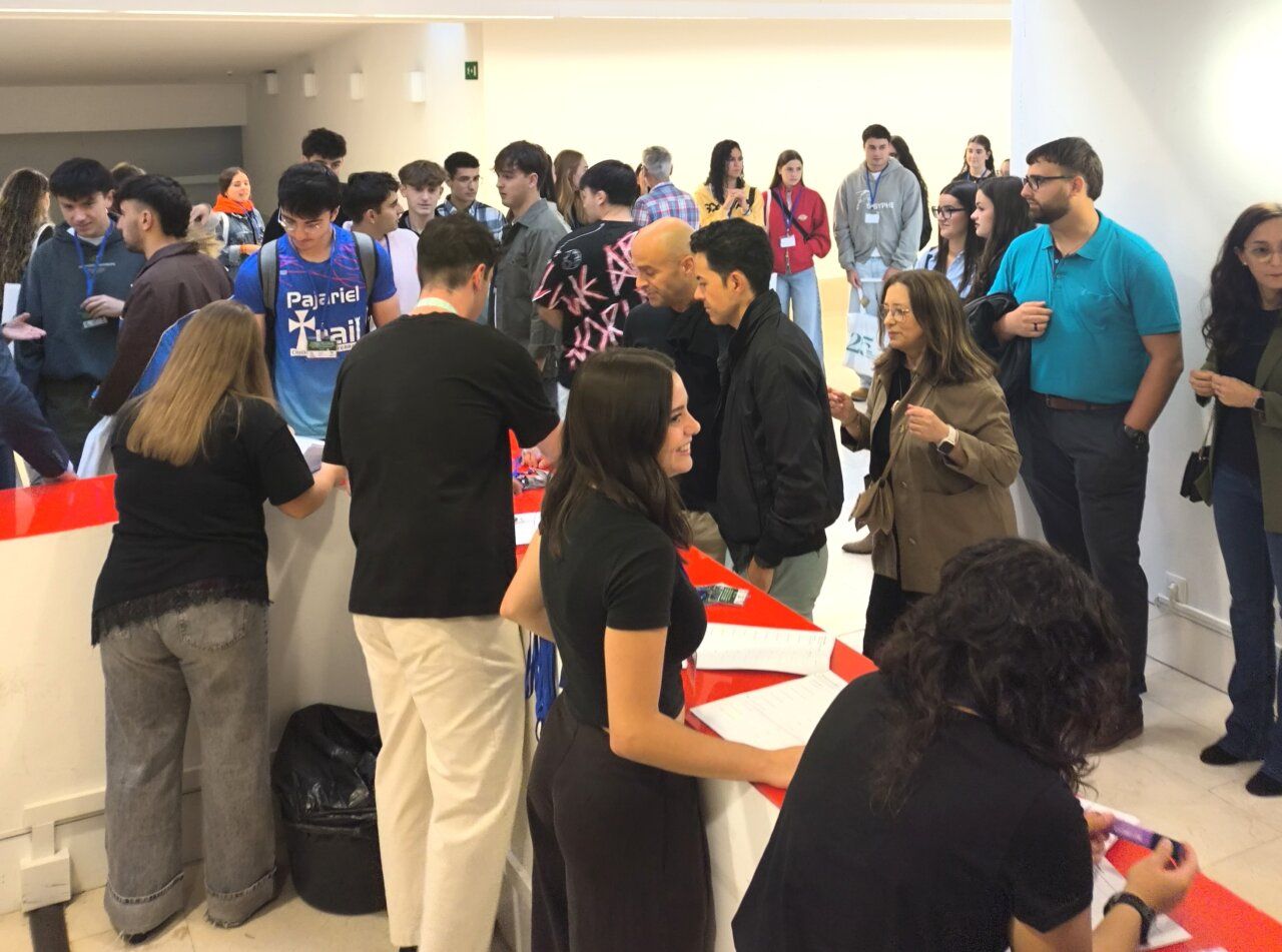 Fotografía de personas reunidas junto a una mesa con documentos en un espacio interior.