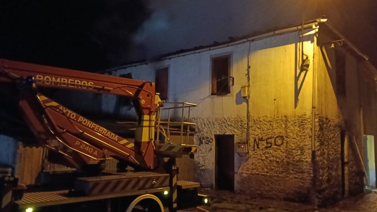 Vehículo de bomberos junto a una vivienda de dos plantas durante la noche