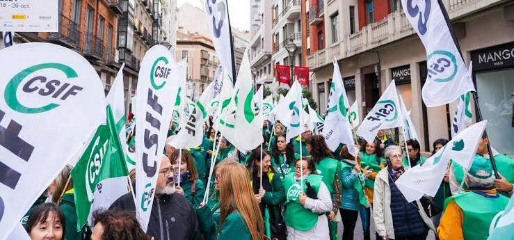 Personas participan en una concentración callejera con numerosas banderas y pancartas de CSIF.