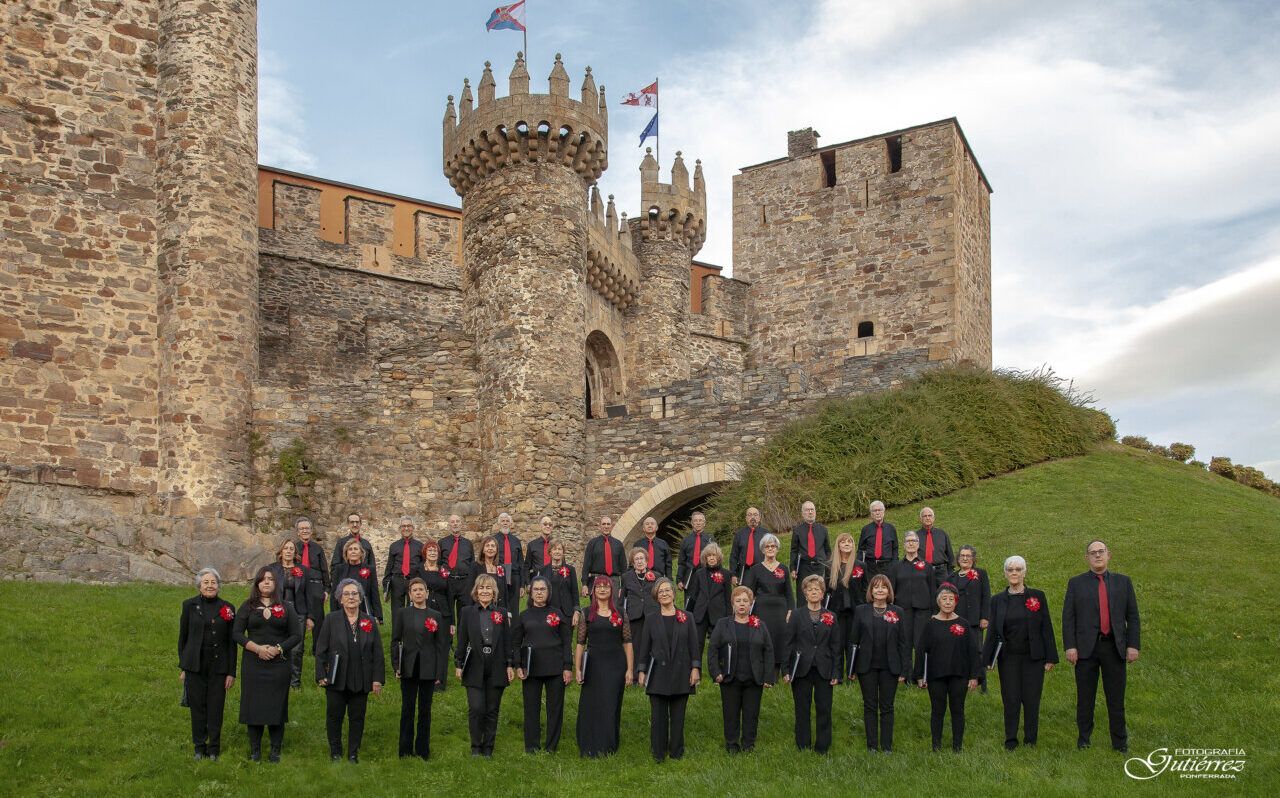 Grupo coral posa ante las murallas del Castillo de los Templarios en Ponferrada