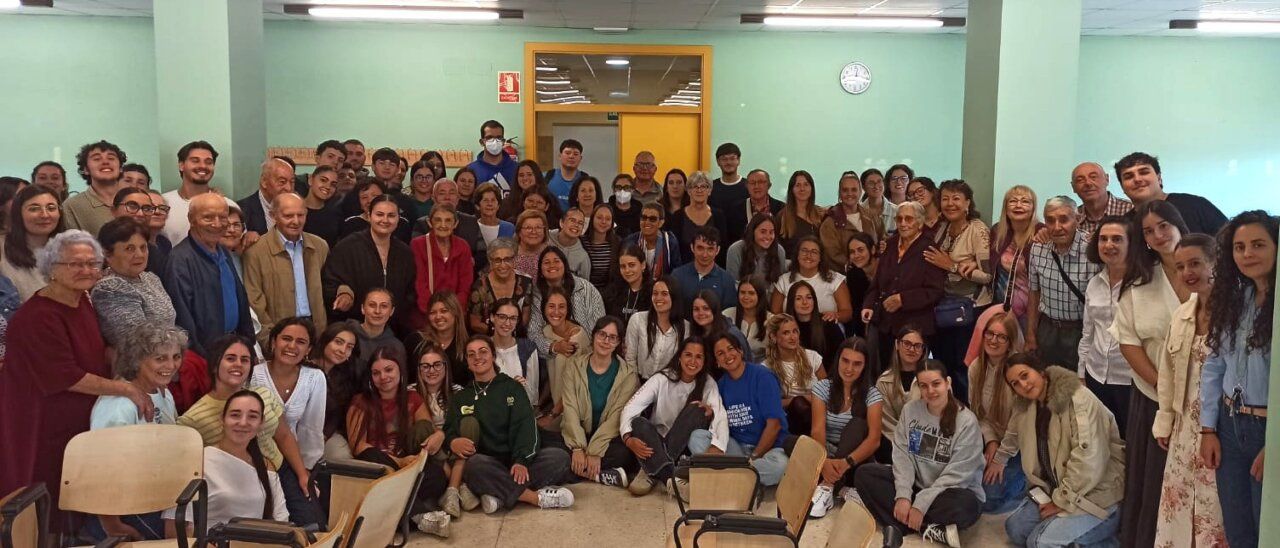 Grupo diverso de personas en un encuentro intergeneracional en el campus.