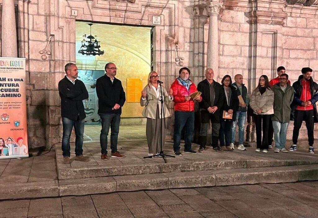 Grupo de personas junto a un micrófono ante la fachada de un edificio histórico.