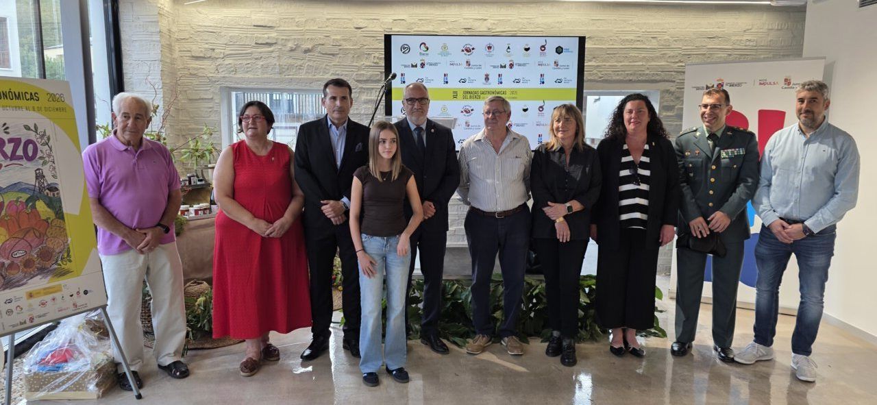 Grupo de personas posa ante carteles de las Jornadas Gastronómicas del Bierzo.
