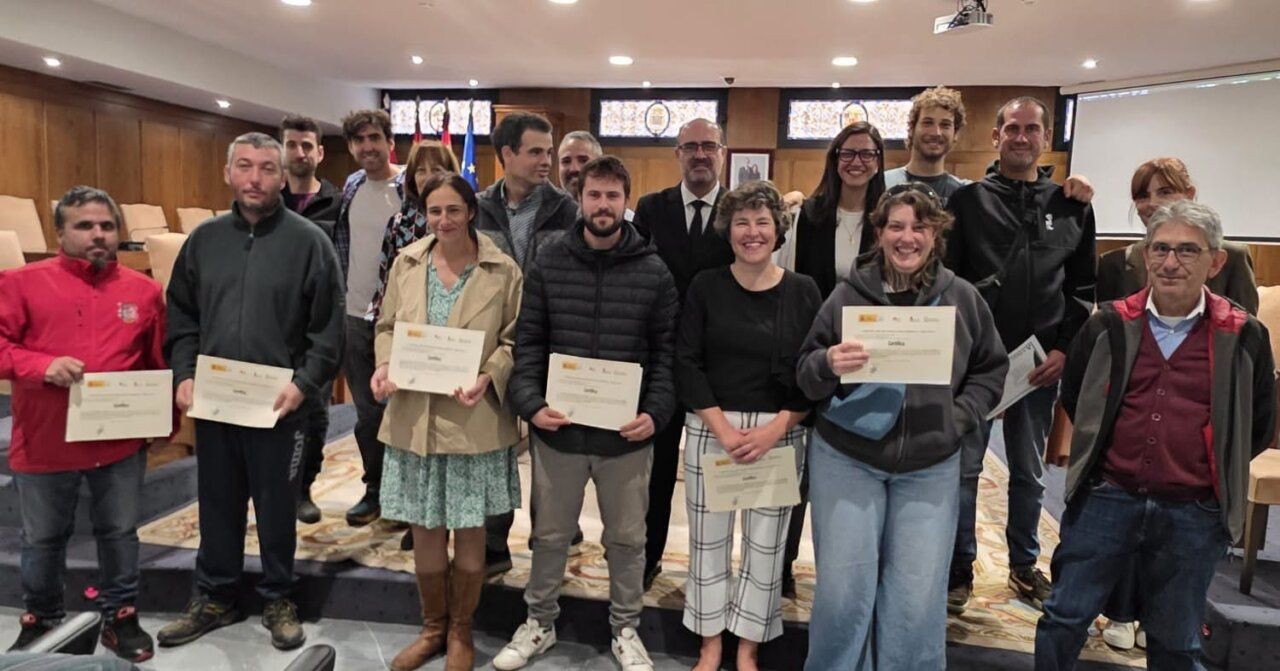 Grupo de personas posa con certificados en una sala municipal
