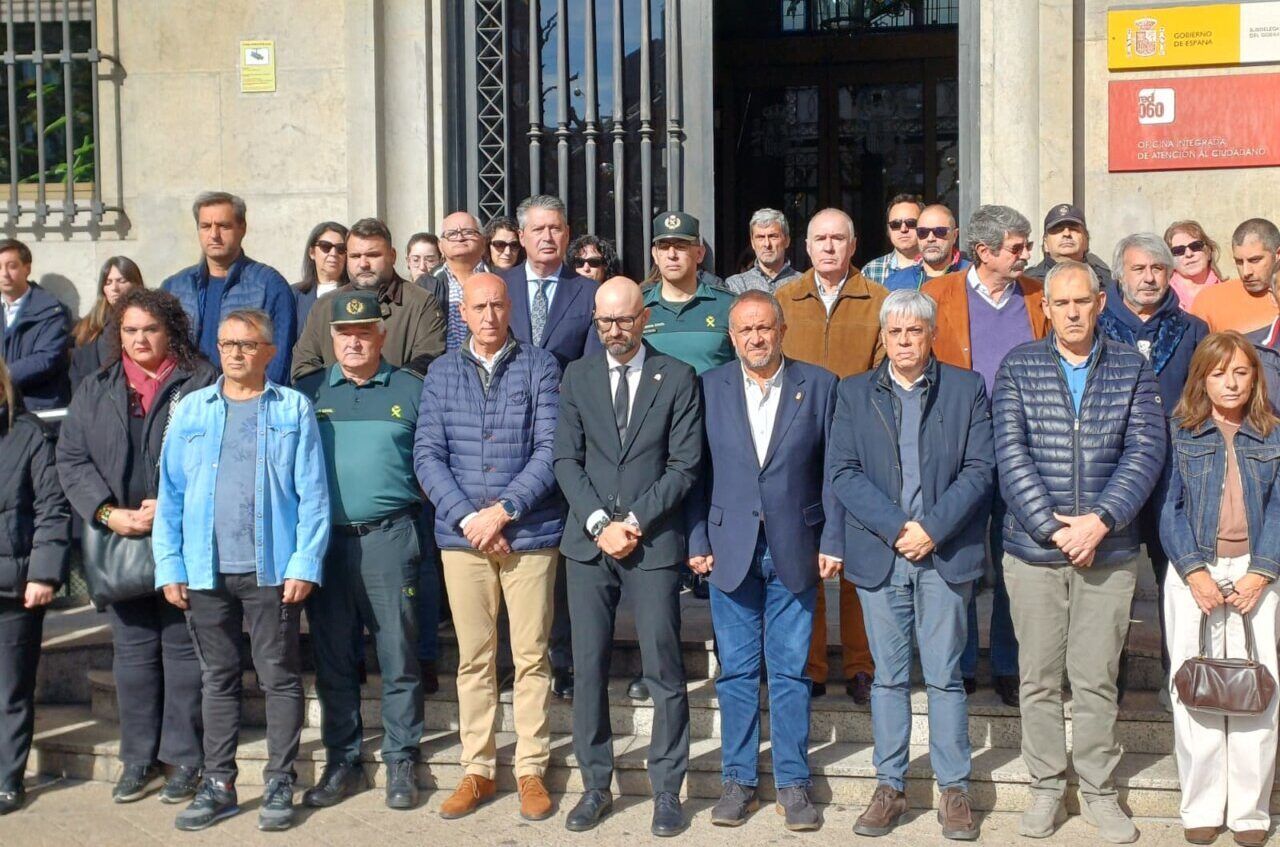 Grupo de personas reunido frente a la entrada de un edificio oficial.