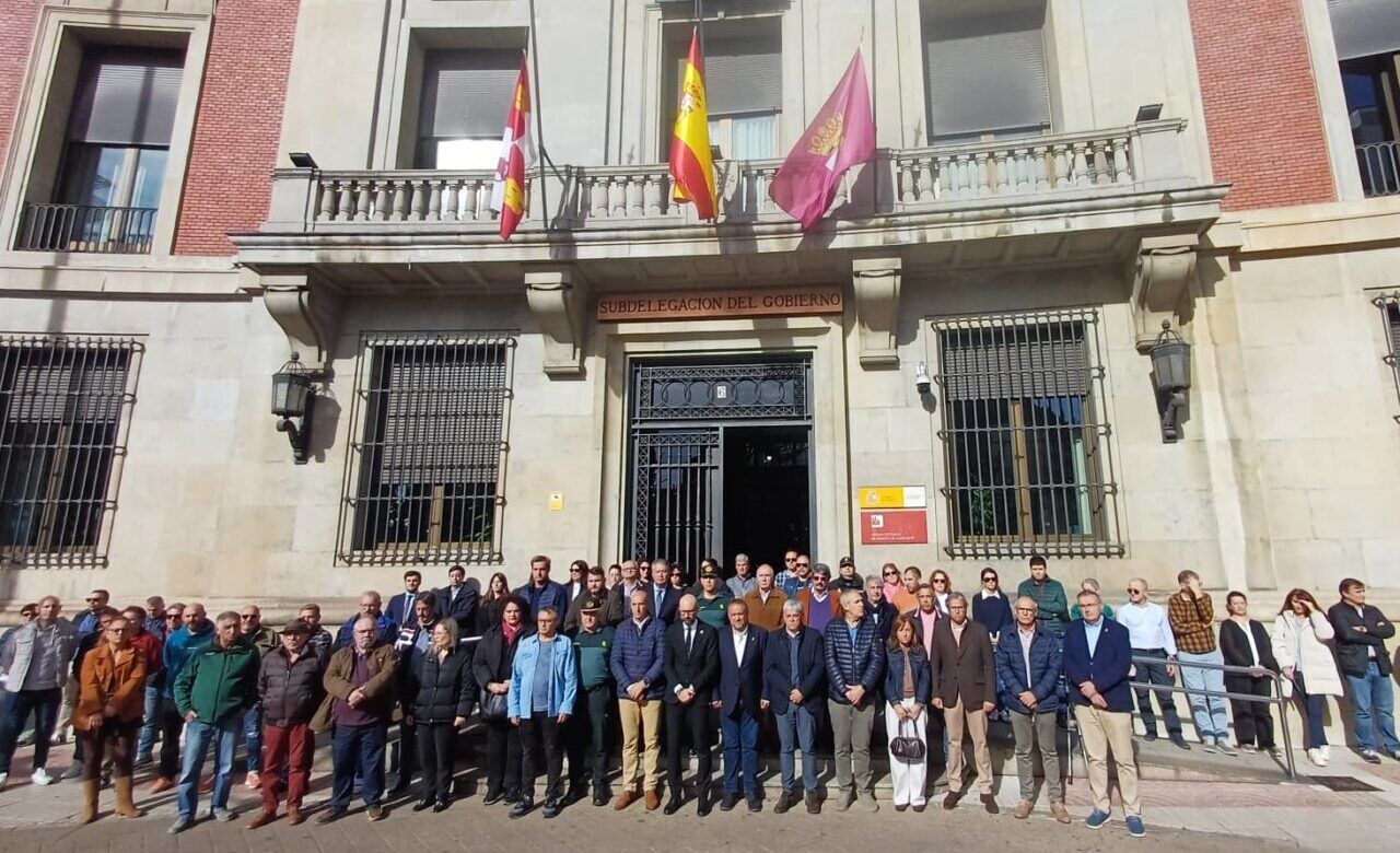 Grupo de personas frente a la Subdelegación del Gobierno, bajo tres banderas