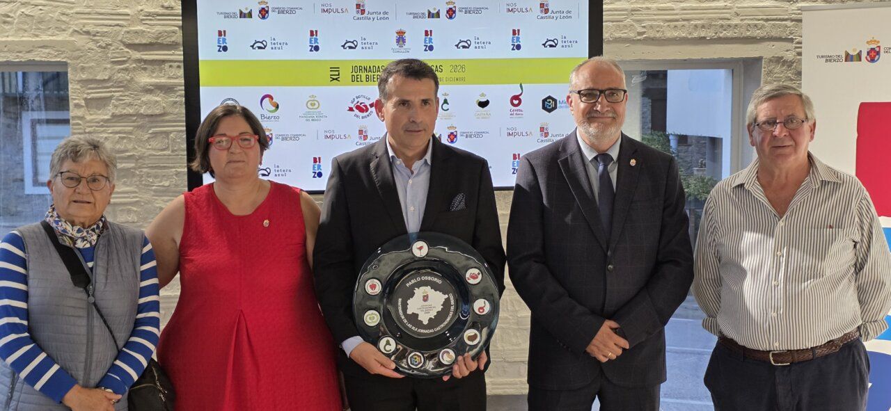 Cinco personas posan ante el panel de las Jornadas Gastronómicas del Bierzo.