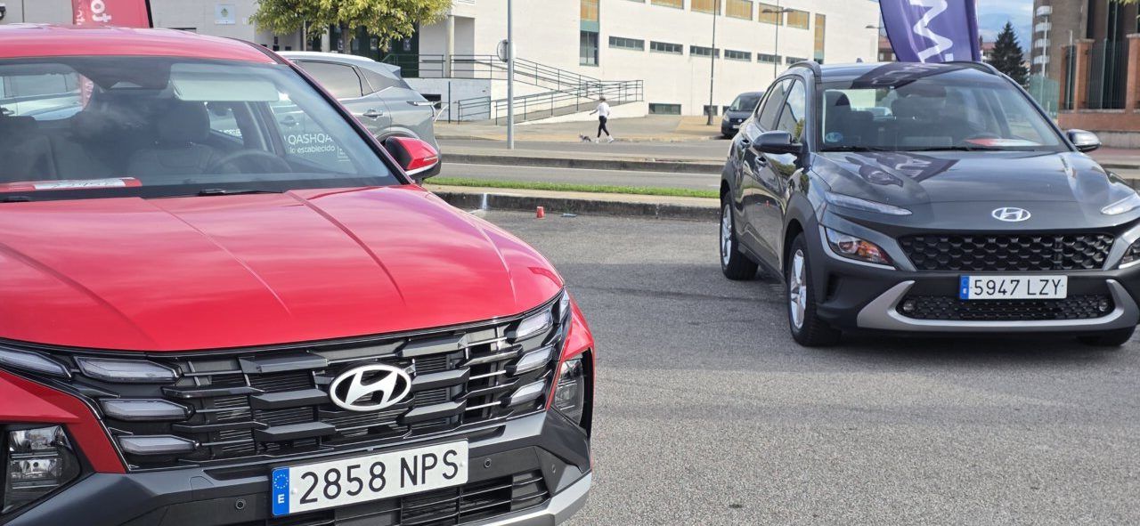 Dos vehículos Hyundai, uno rojo en primer plano y otro gris, expuestos al aire libre.