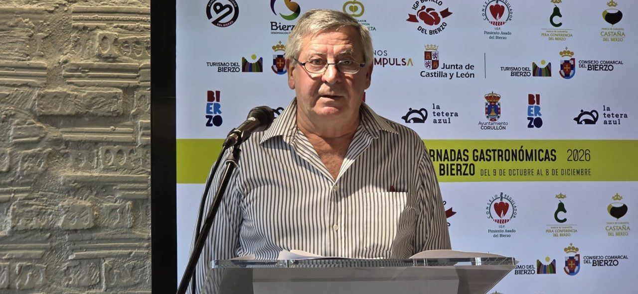 Hombre habla ante un micrófono y atril durante las Jornadas Gastronómicas del Bierzo.
