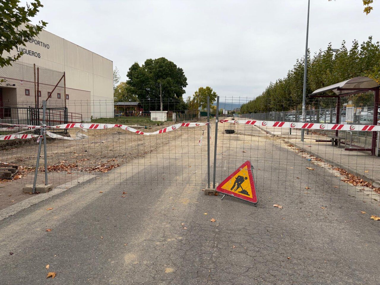 Zona de obras vallada, con cinta de señalización y una señal de trabajos en la calzada