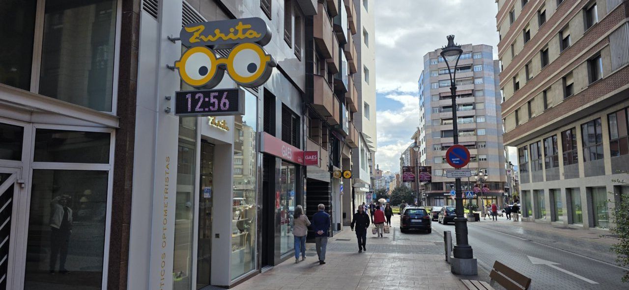 Vista de la óptica Zurita en una calle urbana con gente caminando
