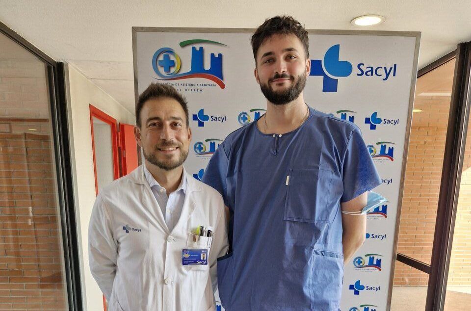 Dos hombres posan ante un panel con logotipos de Sacyl y del Hospital El Bierzo.