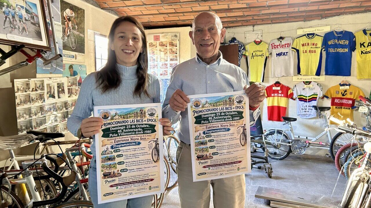 Dos personas sosteniendo carteles de un evento de bicicletas antiguas
