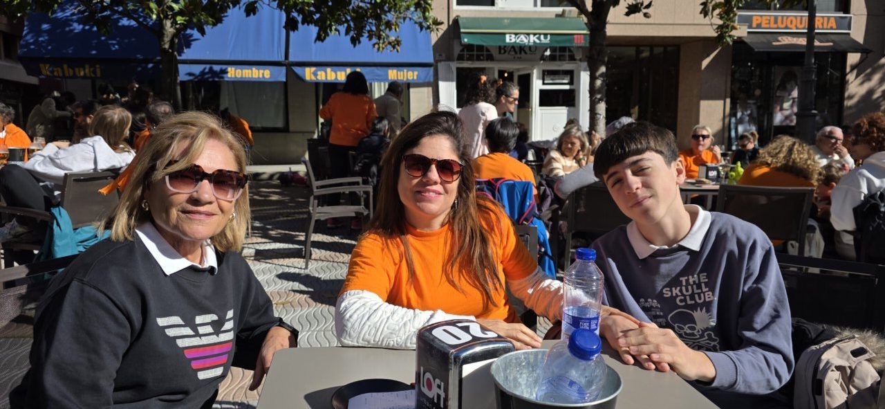 Tres personas sentadas a una mesa en una terraza al aire libre