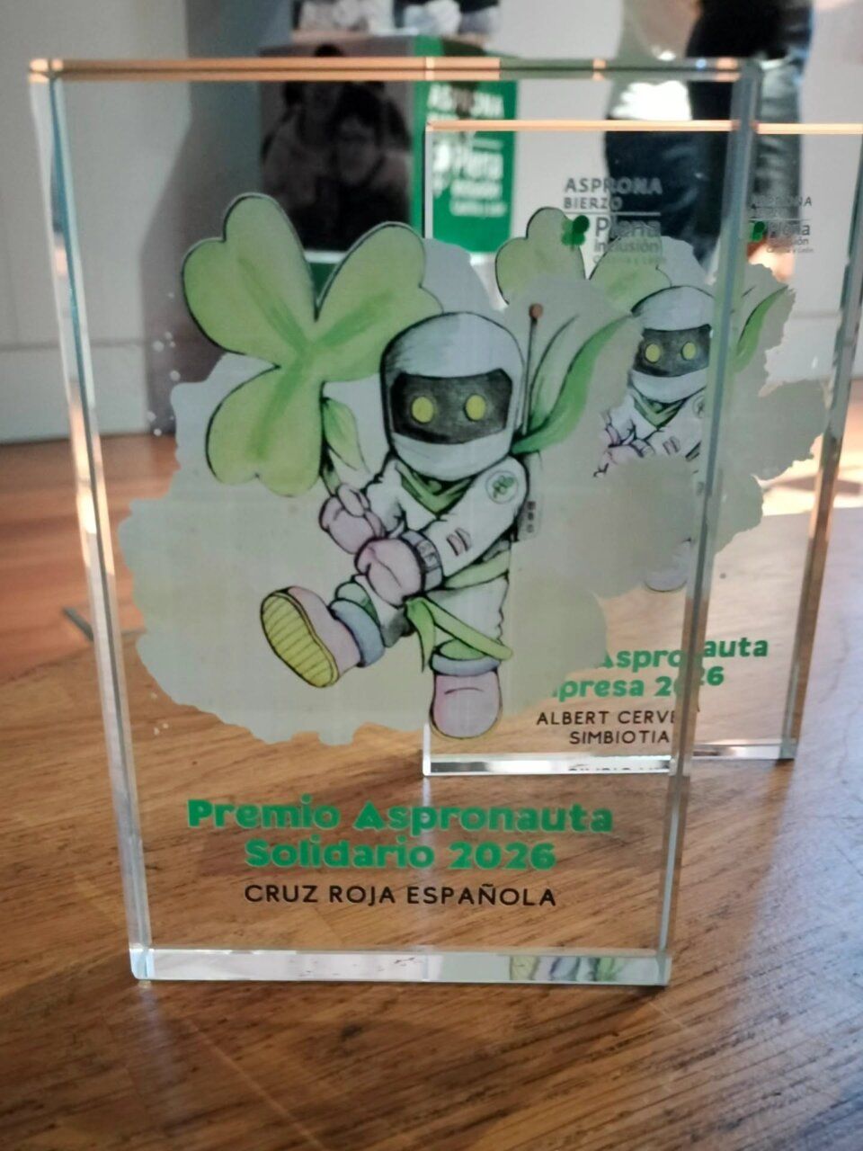 Placa transparente del Premio Aspronauta Solidario 2026 con una ilustración de astronauta.