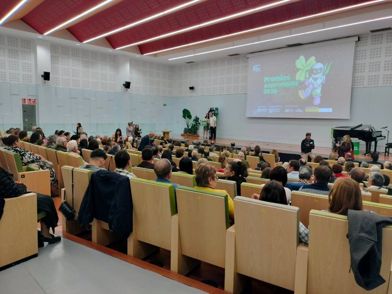 Público sentado en un auditorio frente a una pantalla de los Premios Aspronauta 2026.