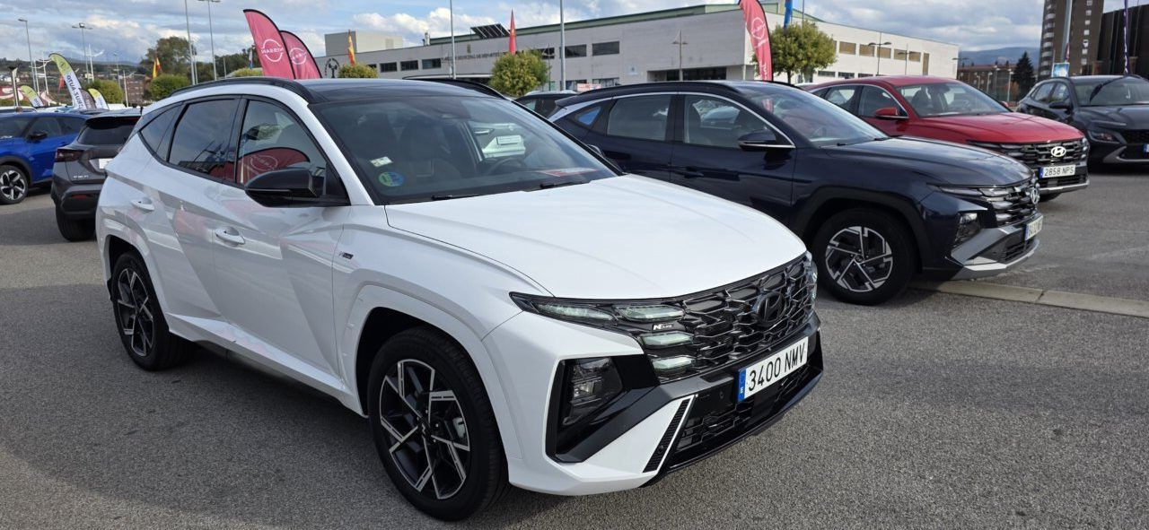 SUV blanco de Hyundai estacionado delante de otros vehículos en una explanada.