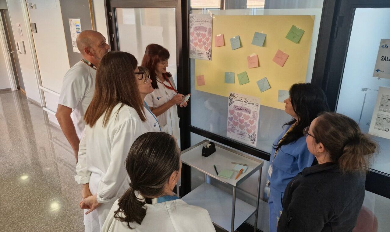 Trabajadores de cuidados paliativos escribiendo mensajes de apoyo en un mural