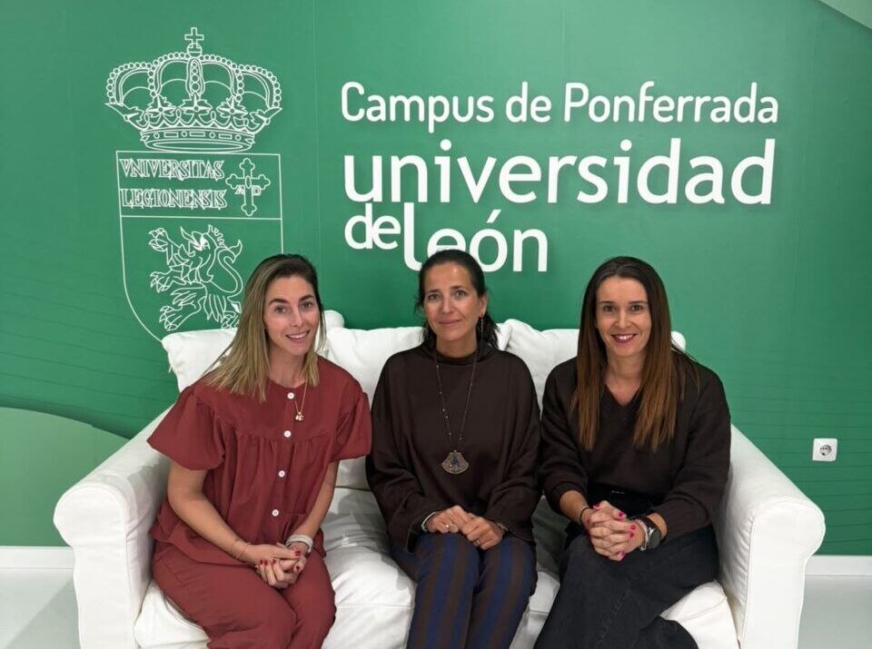 Tres mujeres sentadas en un sofá ante el letrero del Campus de Ponferrada.