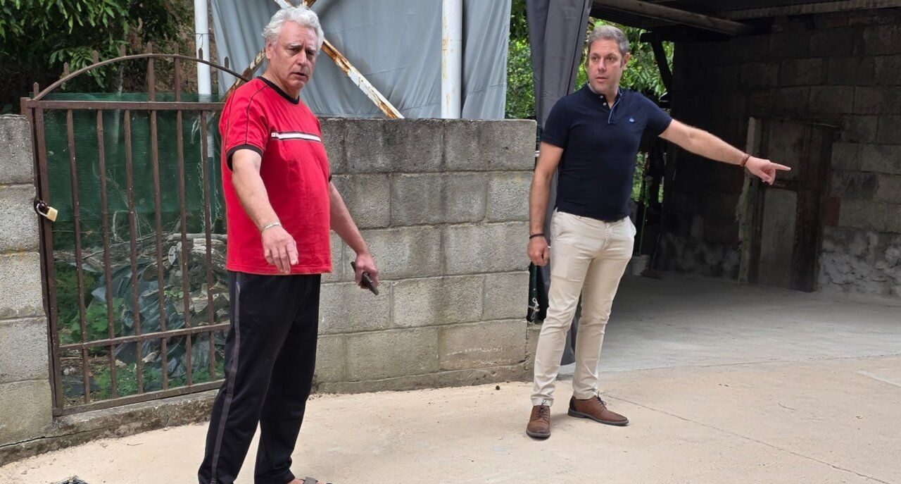 Dos hombres discutiendo sobre mejoras en la calle Bolo en Villanueva de Valdueza.