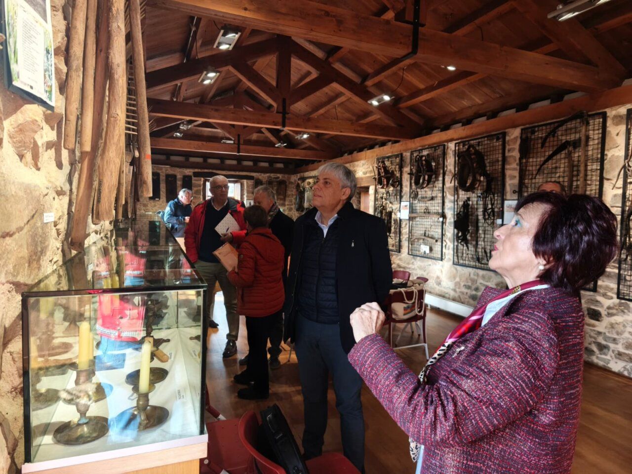 Varias personas recorren una sala de exposición con vitrinas y objetos etnográficos